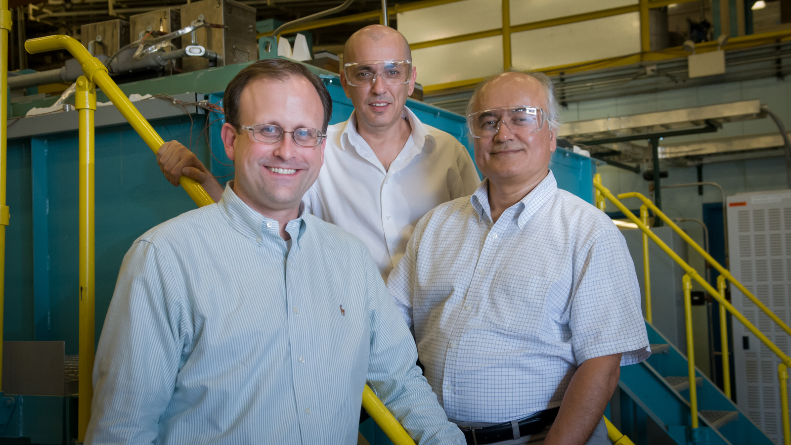Researchers Greg Krumdick, Osman Levent Eryilmaz and Ali Erdemir stand in front of the large-scale ultra-fast boriding furnace, which rapidly converts the surface of metal or alloy mechanical parts into a hard, durable boride layer.