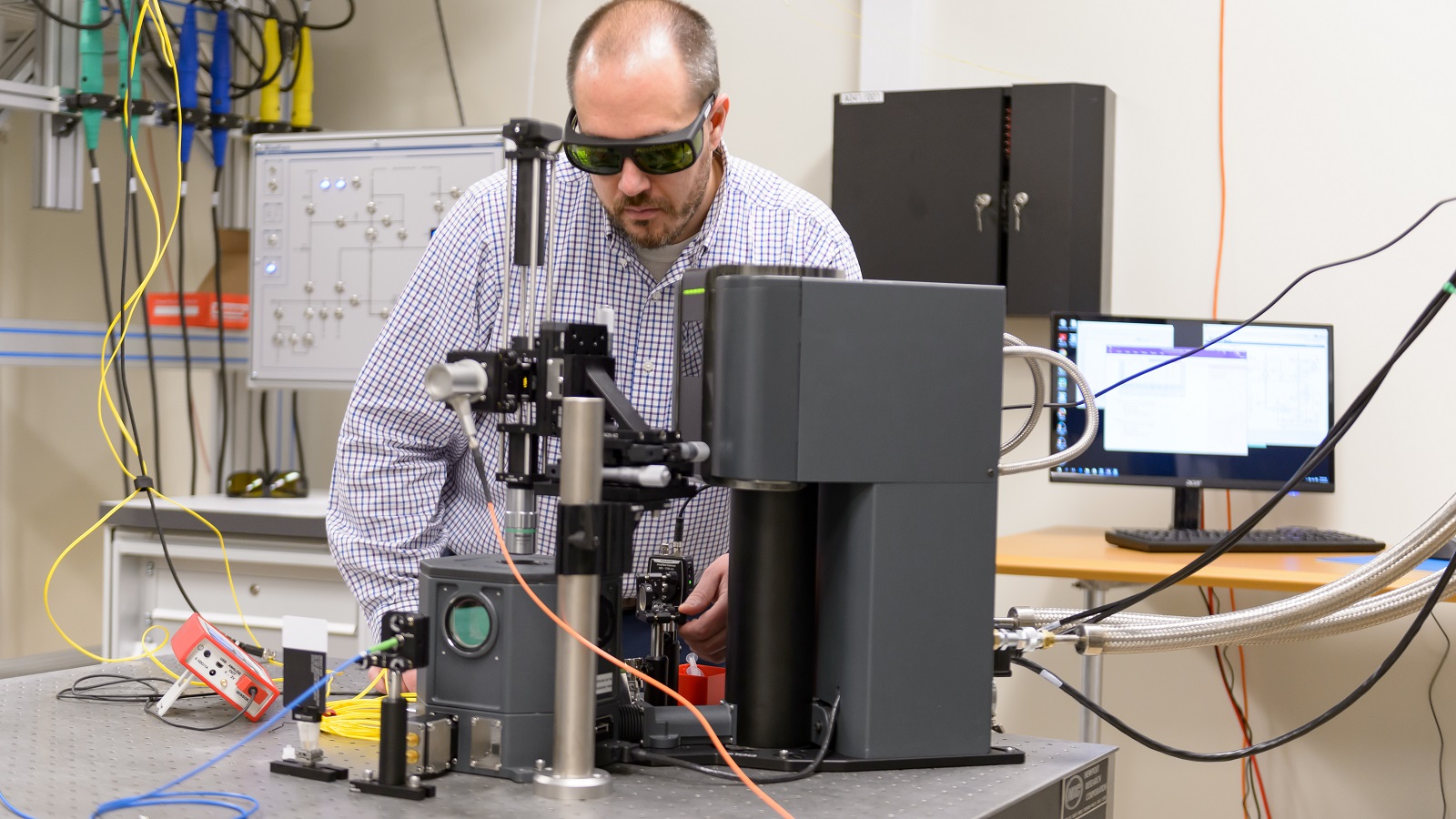 Argonne scientist Alan Dibos aligns optics to bulk ion ensembles in a three-Kelvin cryostat.