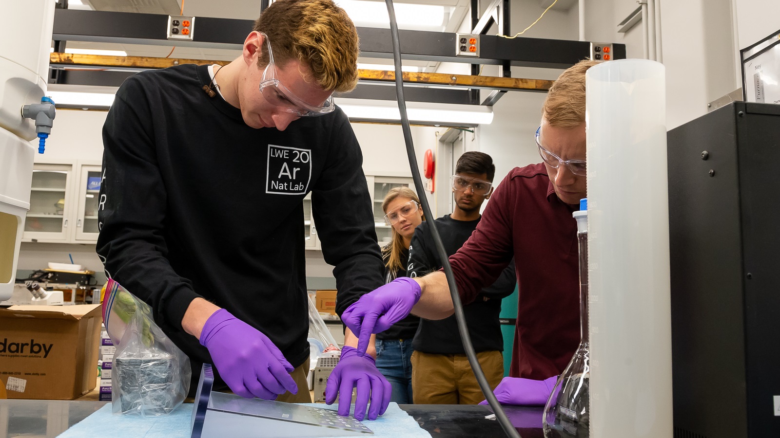 Students from Lincoln-Way East High School in Frankfort work with XSD physicist George Sterbinsky at the aps in February 2020 as part of the ESRP. Students used the APS to experiment with detoxification of metals harmful to the environment. (Image by Mark Lopez/Argonne)