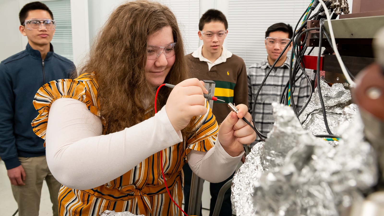 While her classmates look on, a student from Naperville Central High School works on technology at the APS in February 2020 as part of the ESRP. Students work with scientists to design and conduct experiments at Argonne’s research facilities. (Image by Mark Lopez / Argonne National Laboratory.)