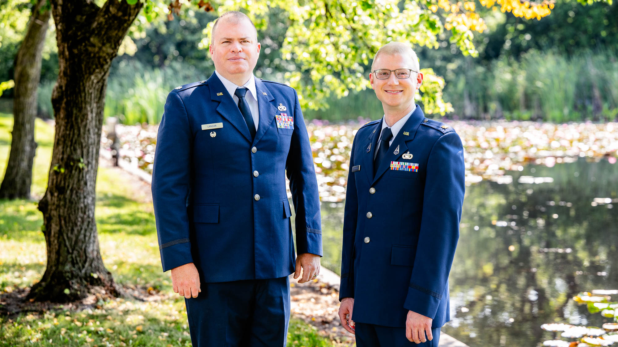 2023-2024 Air Force Fellows, Lieutenant Colonel Joseph D. Langan and Major Justin A. Sadowski stand in front of a lake.