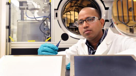 Argonne materials scientist Anil Mane examines a microchannel plate.