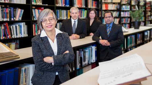 Linda Young, Argonne Distinguished Fellow in foreground and three other people in background of library setting.
