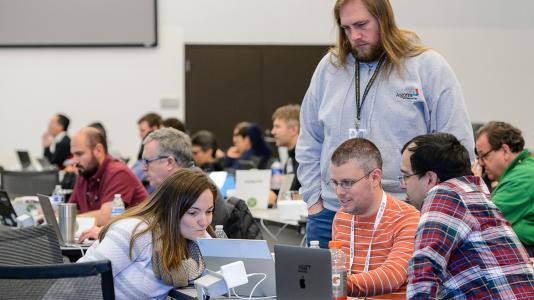 From left: Intel software engineer Louise Huot, NERSC application performance group lead Jack Deslippe, and Argonne computational scientists William Huhn (standing) and Nichols Romero discuss exascale code development at the ALCF’s recent Aurora workshop. (Image by Argonne National Laboratory.)