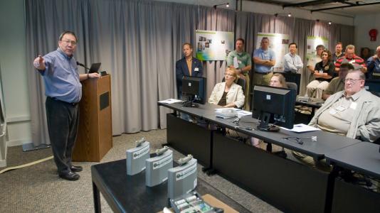 Argonne’s Yung Liu (left) explains the essentials of nuclear packaging and his ARG-US remote monitoring systems technology to students. (Image by Argonne National Laboratory.)