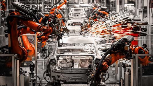 Sparks coming off robotics arms working on car assembly line. (Image by Shutterstock/Jenson.)