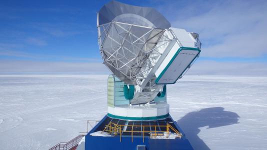 Photographic image of telescope on icy landscape, blue sky background. (Image by Lindsey Bleem/Argonne National Laboratory.)