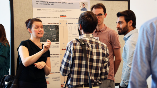 WQRN attendees discuss quantum communication and networking research during a poster session. (Image by Megan Rouse, Chicago Quantum Exchange.)