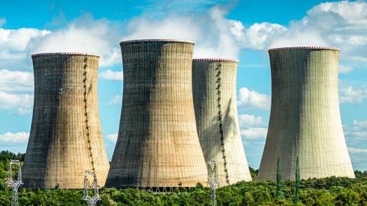 Four nuclear power plant cooling towers against blue sky. (Image by Shutterstock/Stefan_Sutka.)