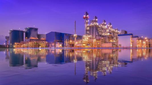 Natural gas combined cycle power plant reflection and Turbine generator with blue sky. (Image by Shutterstock/ETAJOE.)