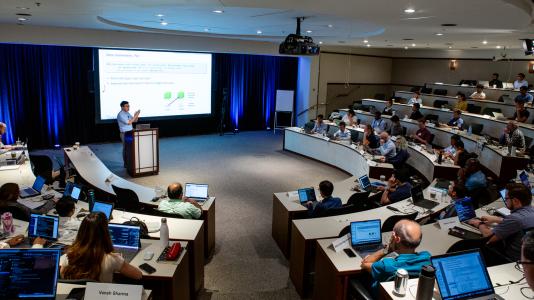 Argonne computer scientist Yanfei Guo stands teaching attendees at the 2023 Argonne Training Program on Extreme-Scale Computing.  