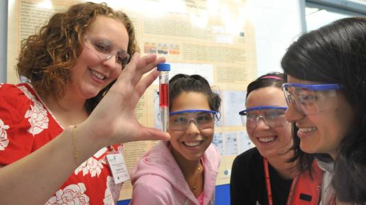 From left: Teacher Heather Scott and students Stephanie Lamas, Dana Bielinski and Smriti Marwaha examine a test tube at Science Careers in Search of Women.