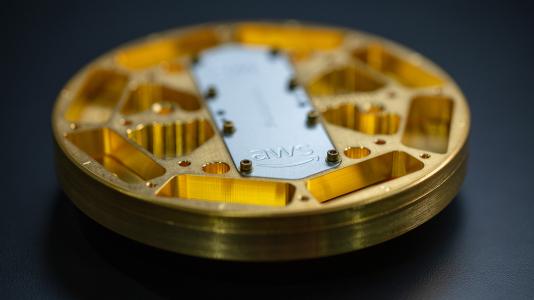 Amazon Web Services will contribute fundamental research to the Q-NEXT community to advance the use of quantum technologies. Pictured here is an AWS microwave package enclosing a quantum processor. The packaging is designed to shield the qubits from environmental noise while enabling communication with the control system. 