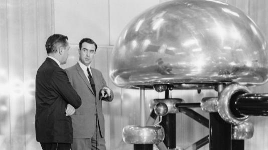 Albert Crewe (right), Argonne director from 1961 to 1967, explains the ZGS's Cockroft-Walton pre-accelerator.